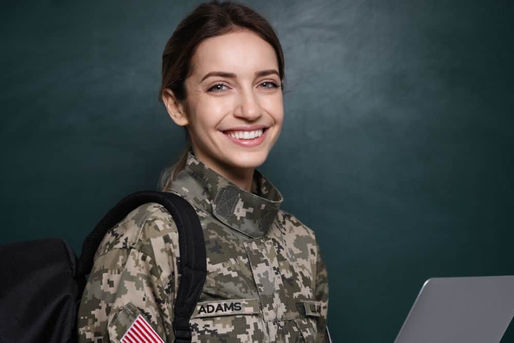 Female cadet with backpack and laptop near chalkboard