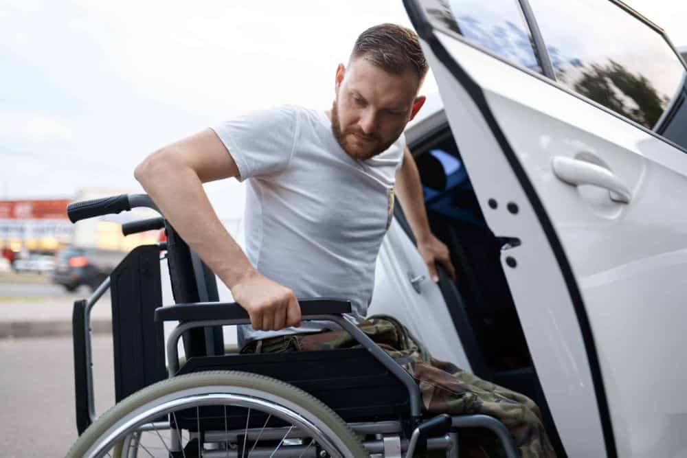 Disabled veteran transfers from car to wheelchair