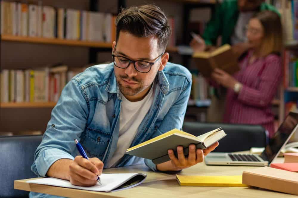 Young male student studying in the library