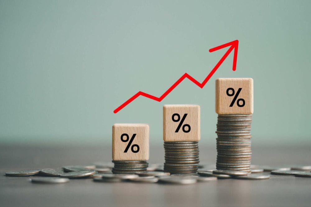 Percentage sign on a wooden cube with rows of coins